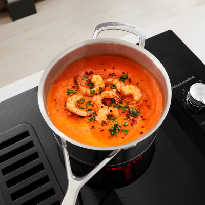 Shrimp cooking in a sauce pan on an electric stove