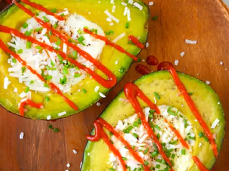 Baked avocado eggs with a drizzle of sriracha