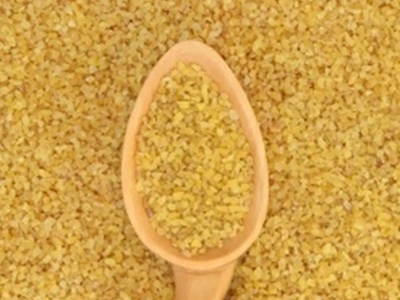 A spoon in a mound of bulgur.
