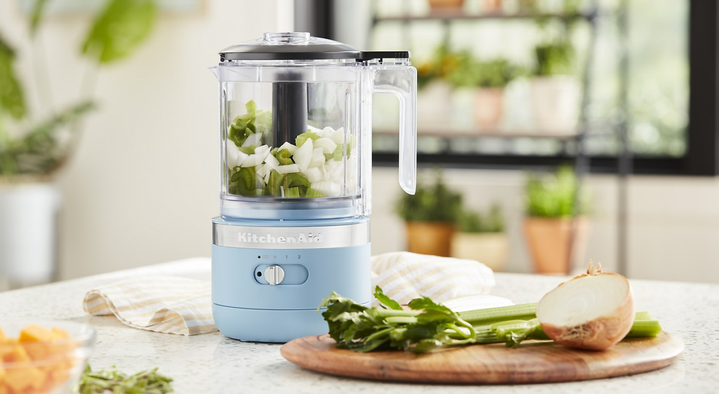 A KitchenAid® food processor filled with celery and onions
