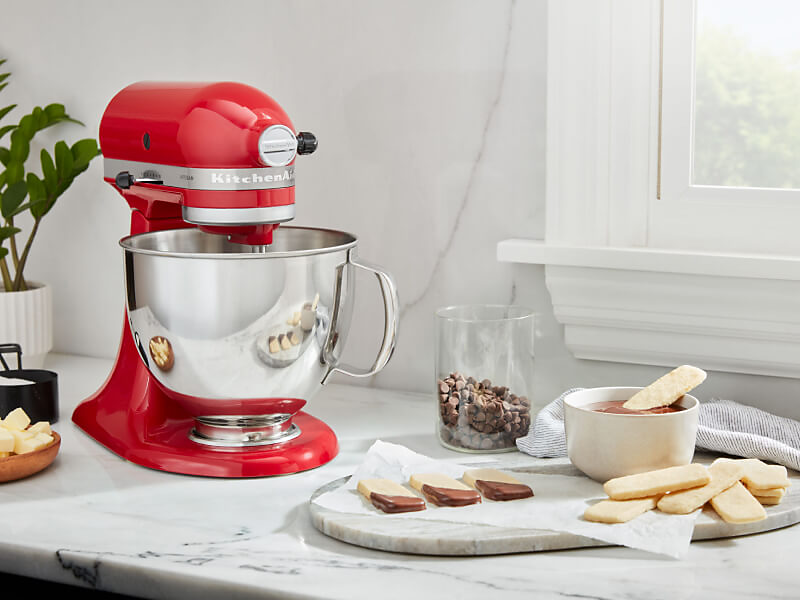 A red KitchenAid® stand mixer and a prepared dessert on a countertop 