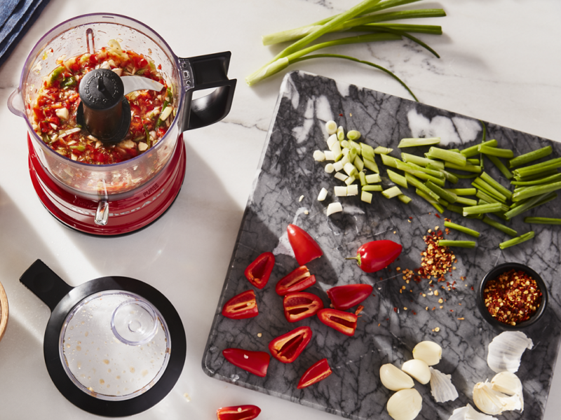 A KitchenAid® food chopper with assorted vegetables nearby.