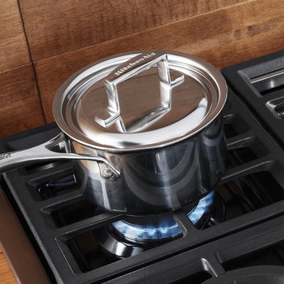 Saucepan with a lid heating on a gas cooktop