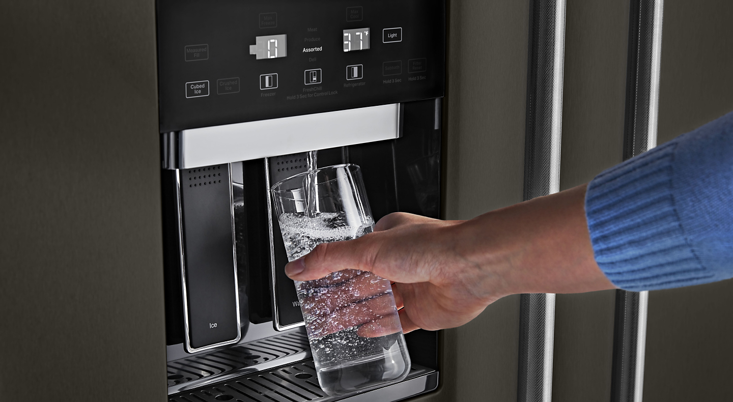 Person filling water from refrigerator dispenser