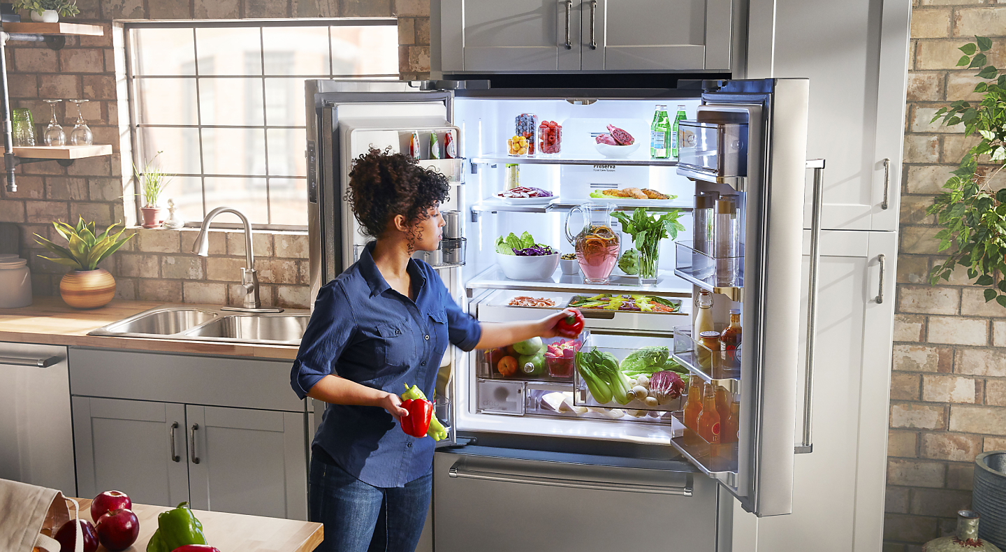 Person removing produce from KitchenAid® refrigerator