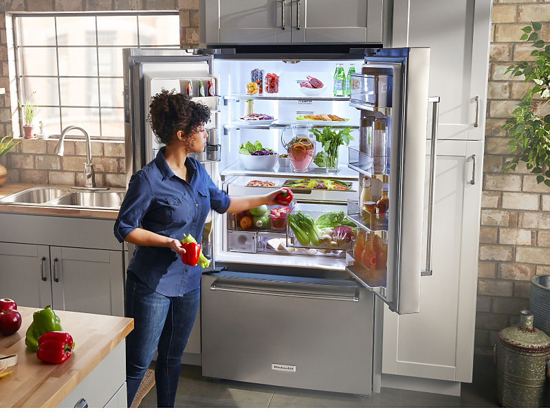 Person removing produce from KitchenAid® refrigerator