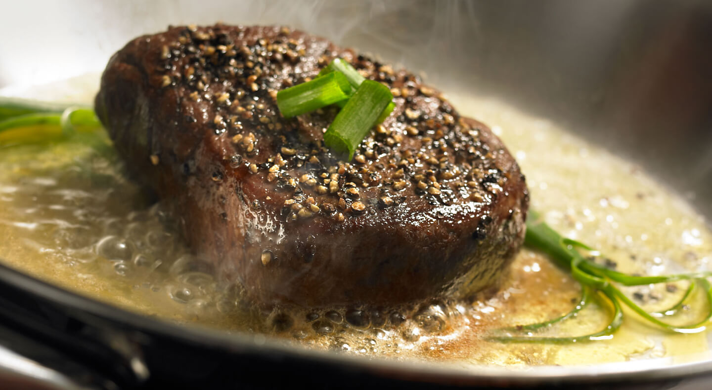 Cooked steak topped with green onions