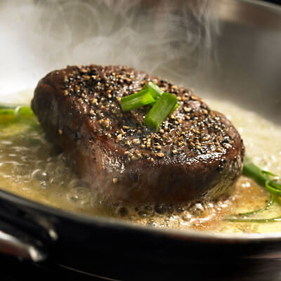 Cooked steak topped with green onions