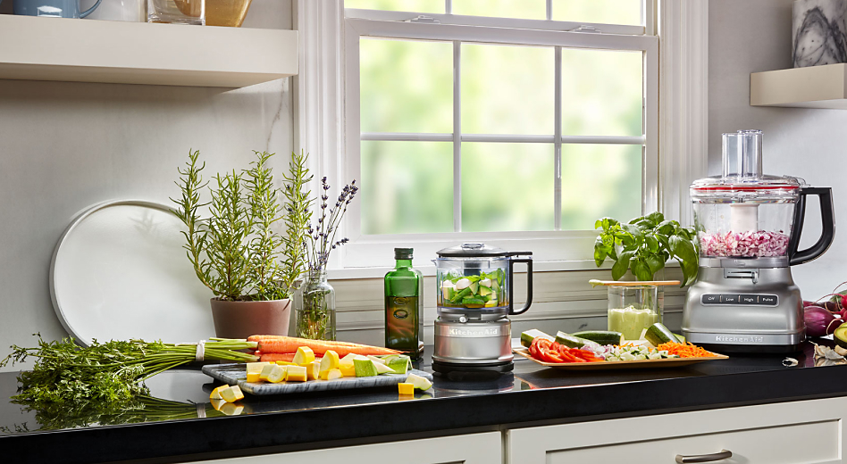 Vegetables being prepped on a counter next to KitchenAid® countertop appliances