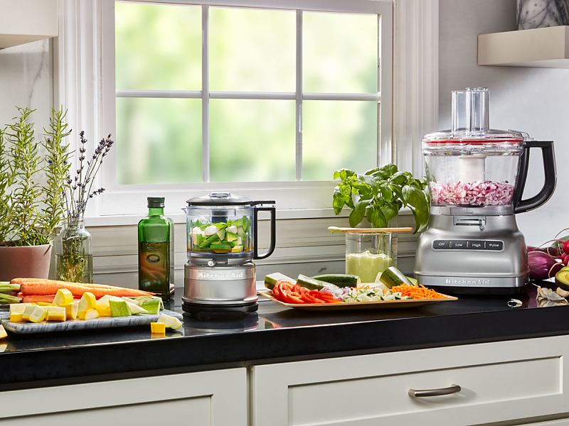 Vegetables being prepped on a counter next to KitchenAid® countertop appliances
