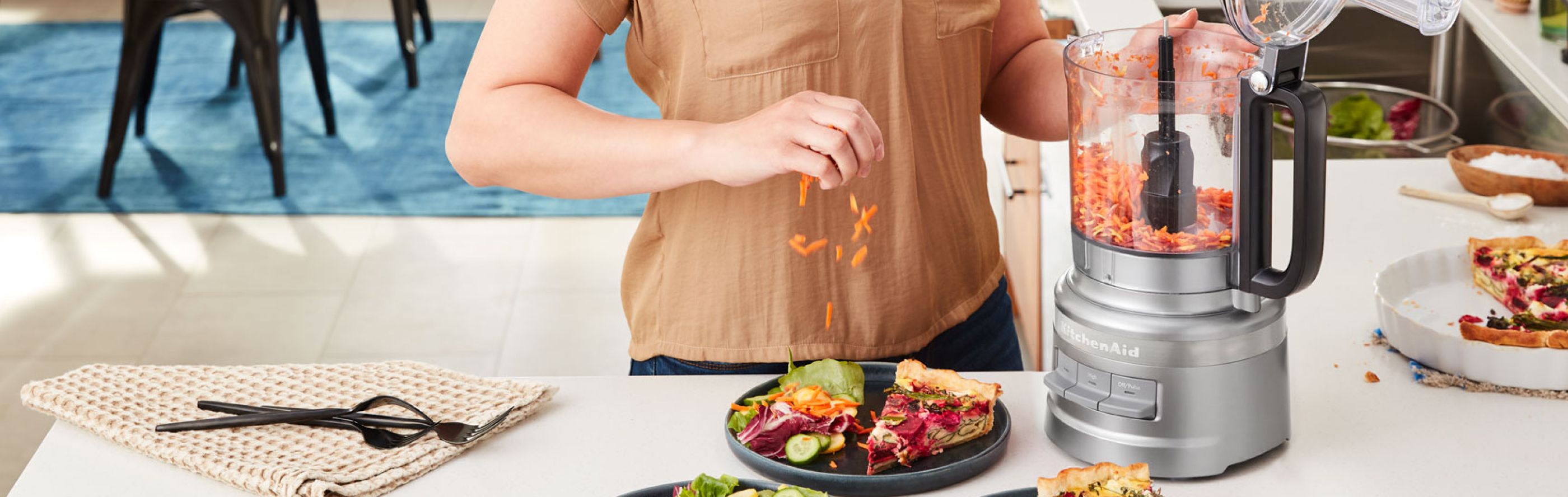 Woman shredding carrots in a KitchenAid® food processor