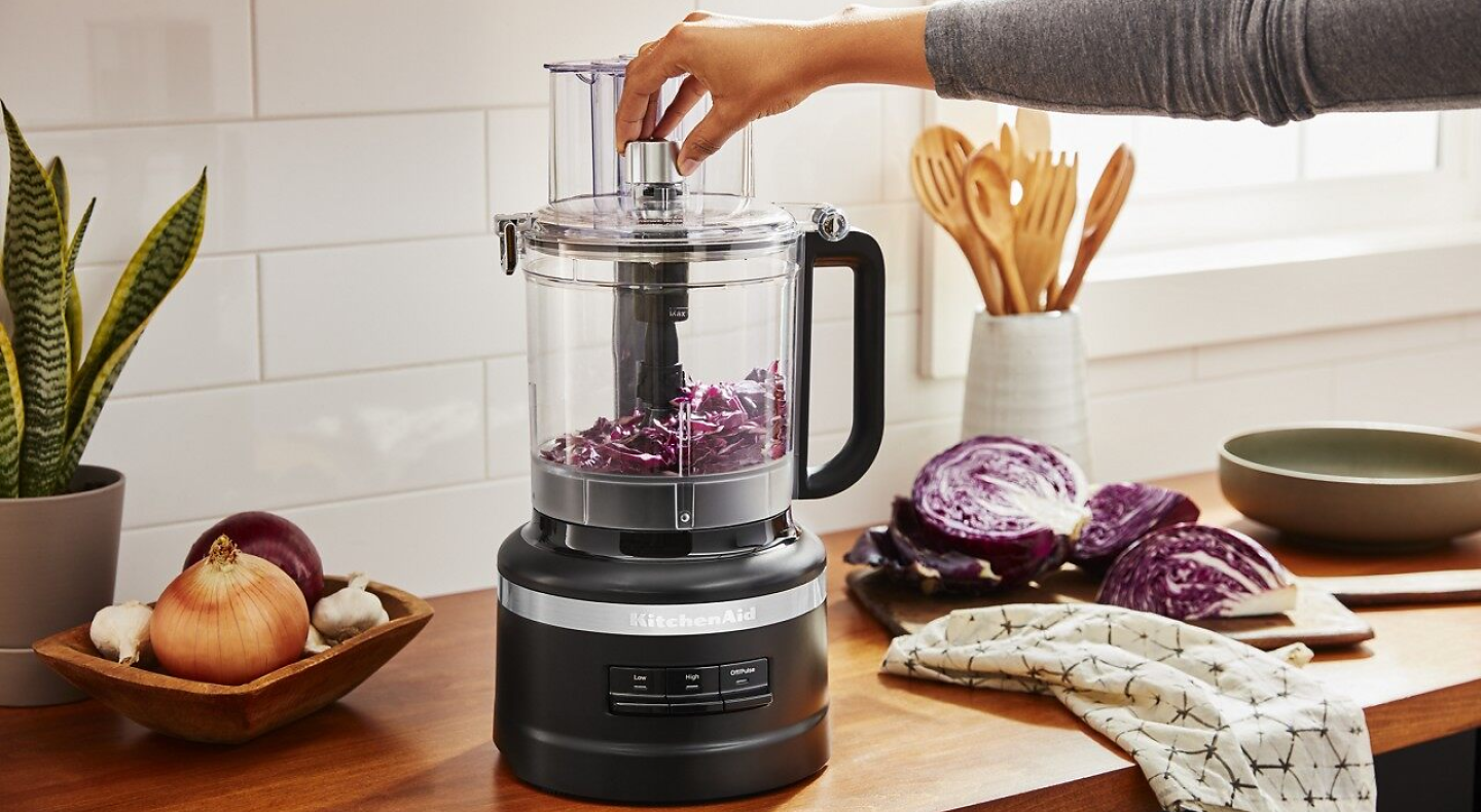Woman dicing vegetables in a KitchenAid® food chopper