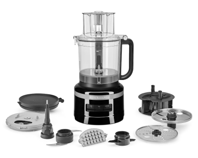 Black food processor surrounded by various food processor accessories