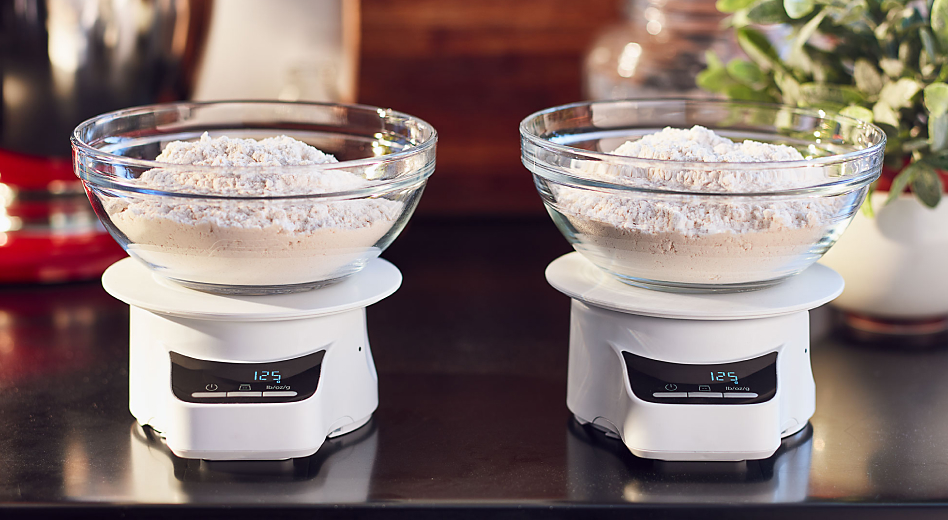 Two bowls of flour on two scales