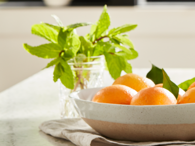 Bowl of oranges next to a jar of fresh herbs