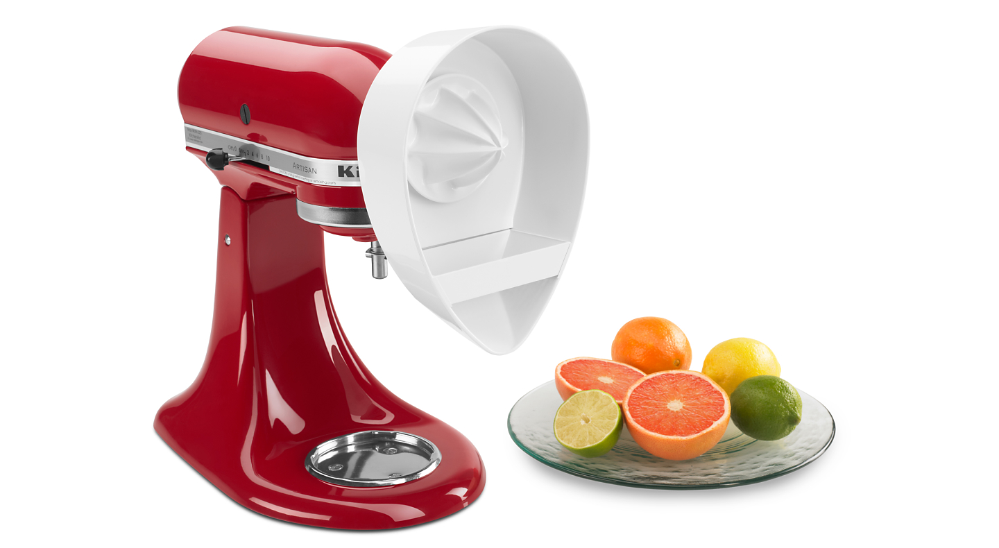 Sliced fruits next to a red KitchenAid® stand mixer with Citrus Juicer Attachment
