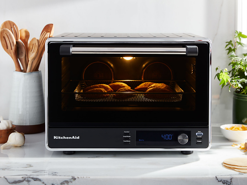 Empanadas cooking inside a black KitchenAid® countertop oven