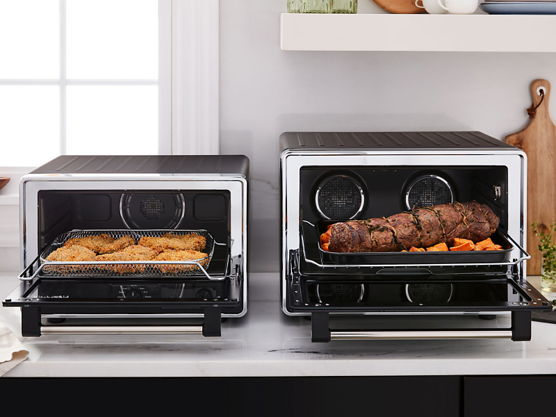 Two countertop ovens side-by-side featuring different meals