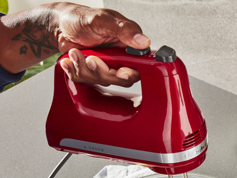 Person pressing button on KitchenAid® hand mixer