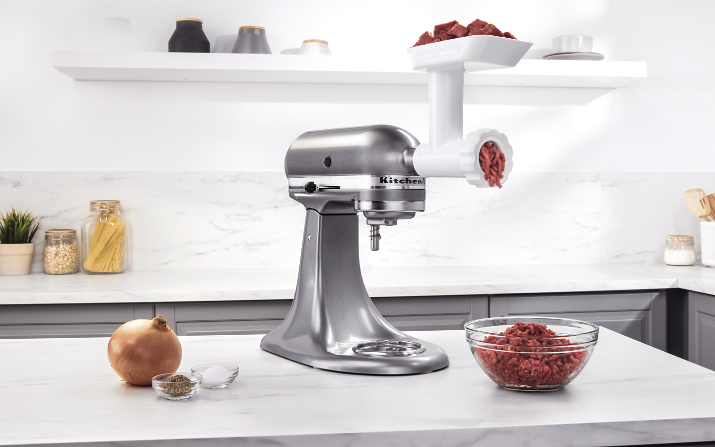 Silver stand mixer with white meat grinder attachment grinding beef