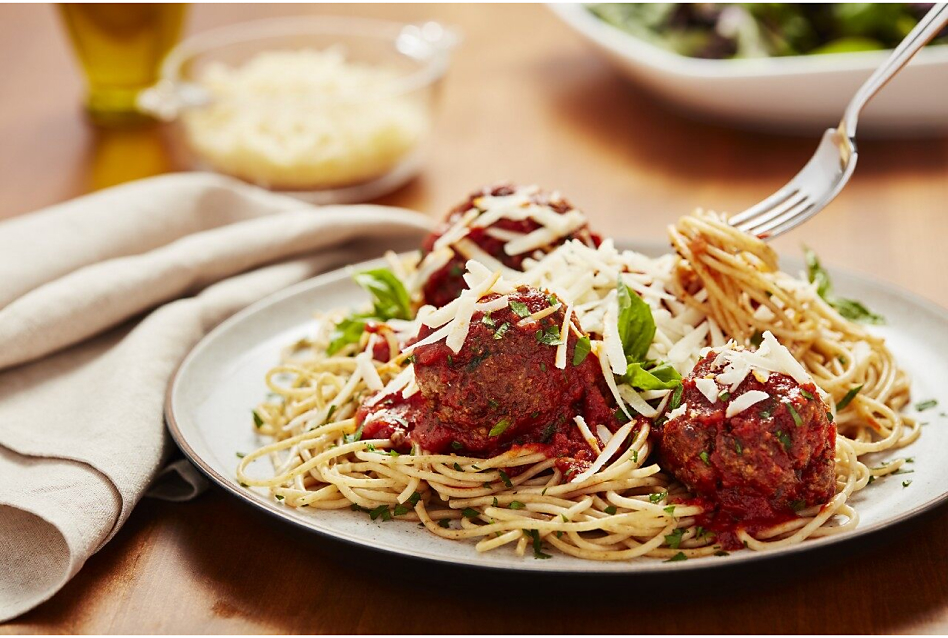 Plate of spaghetti and meatballs with fork twirling noodles