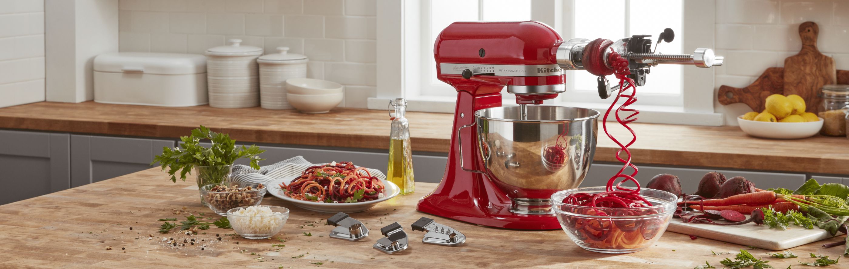 A red KitchenAid® Stand Mixer with Spiralizer Attachment.