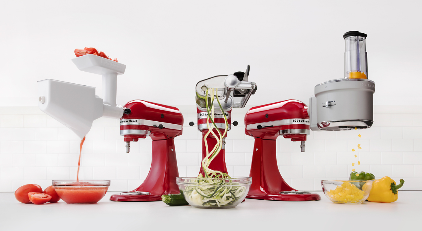 Lineup of KitchenAid® accessories attached to red KitchenAid® stand mixers