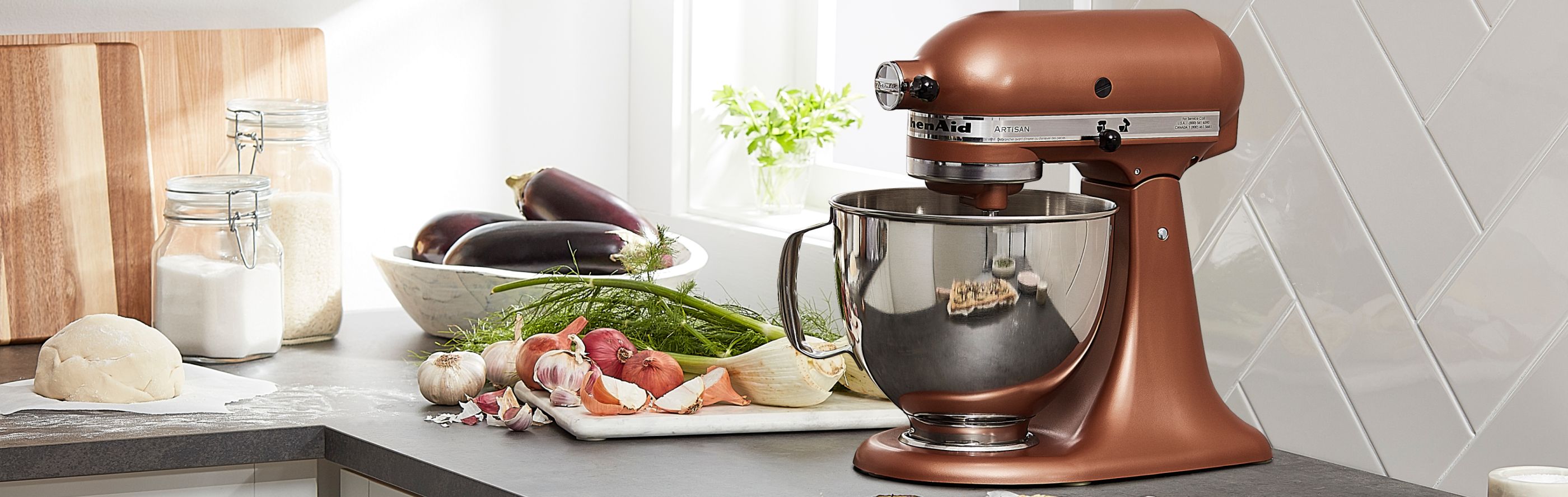 Copper KitchenAid® stand mixer next to vegetables on counter 