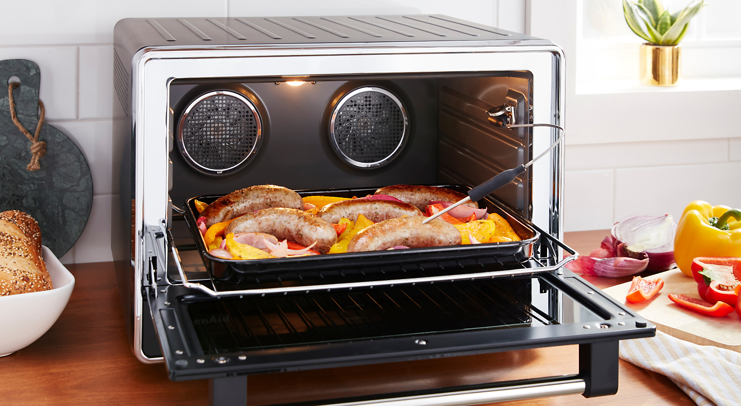 Meat and produce on air fryer tray with door open.