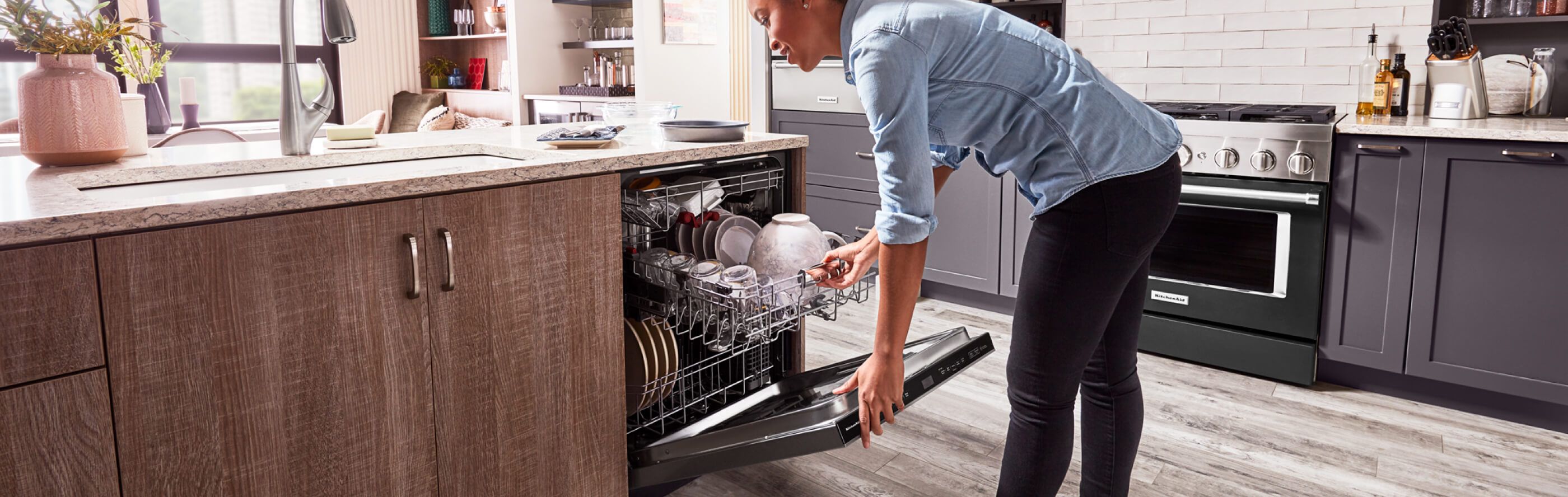 Person closing a loaded dishwasher 