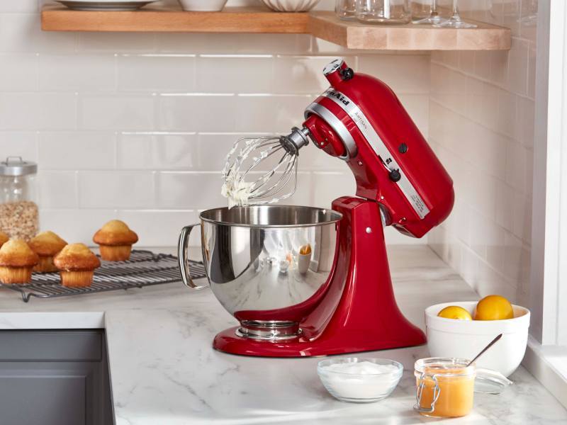 KitchenAid® stand mixer with a wire whip accessory with stiff egg white peaks in modern kitchen.
