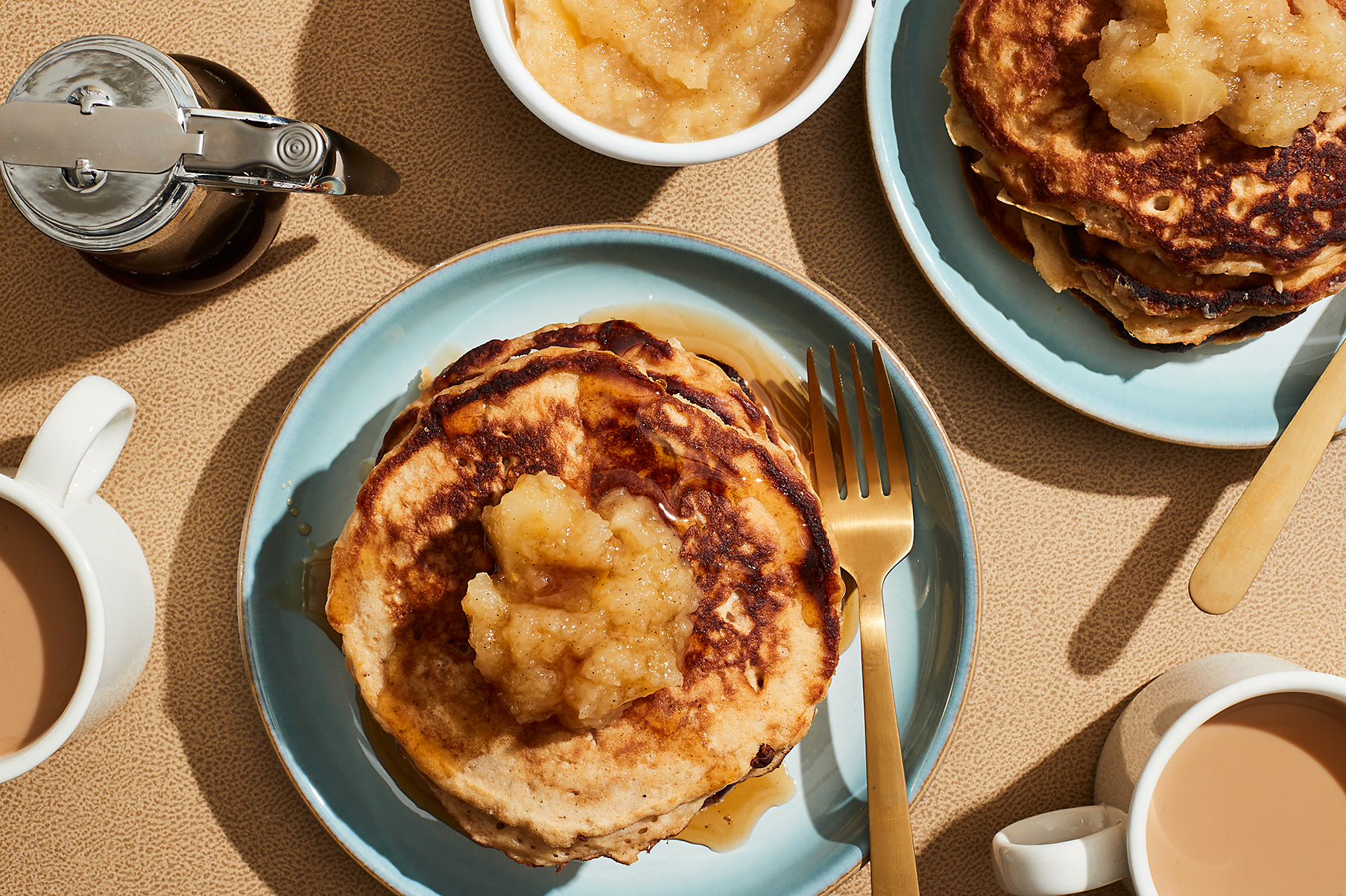 Small stack of applesauce pancakes on a round, light blue plate