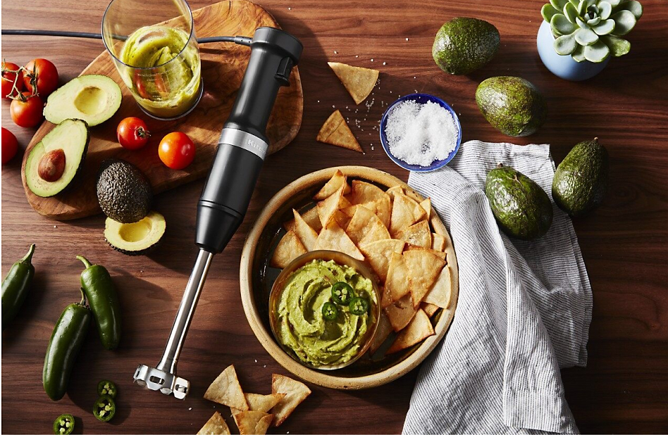 View of fresh produce and KitchenAid® hand blender next to bowl of guacamole
