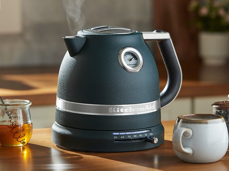 Black KitchenAid® electric kettle next to tea accessories and honey