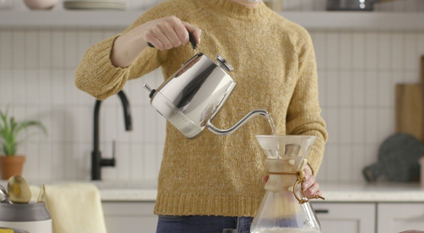 Woman making pour over coffee with a gooseneck kettle