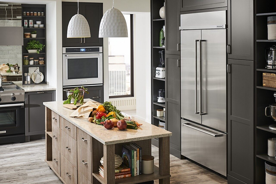 Stainless steel built-in refrigerator in a grey kitchen