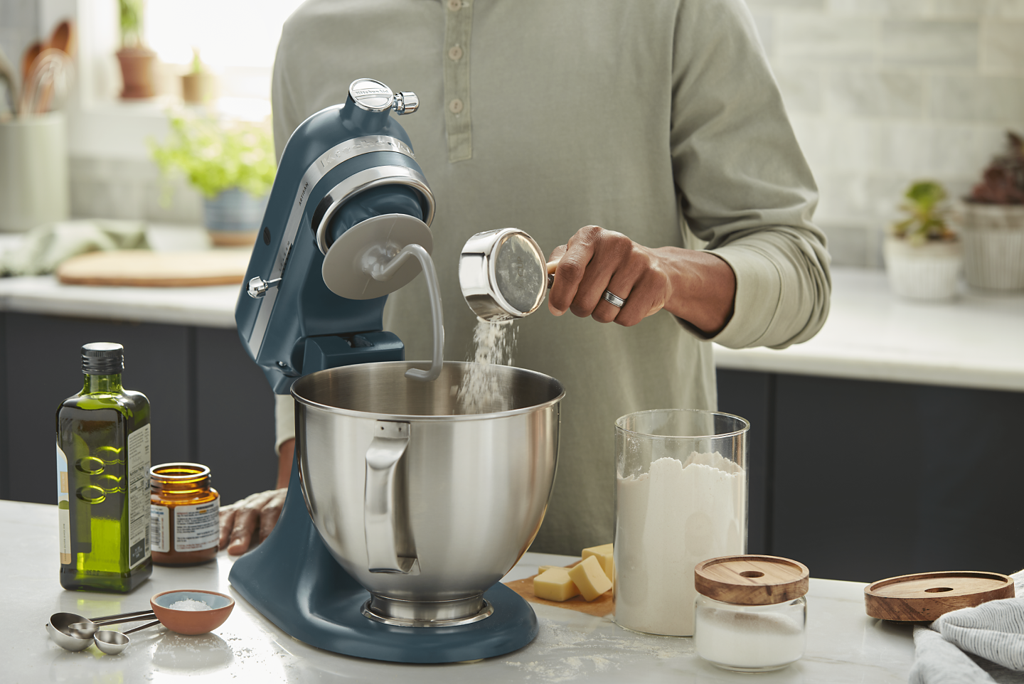Person adding ingredients into a KitchenAid® stand mixer