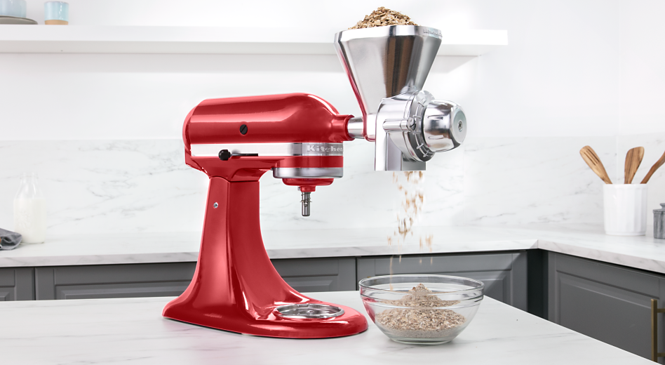 A KitchenAid® stand mixer fitted with an All Metal Grain Mill attachment