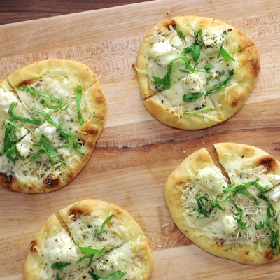 White cheese and garlic pizzas on a wood platter