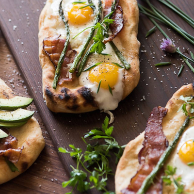 Brunch pizza topped with egg, asparagus and bacon