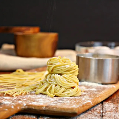 Pile of freshly-rolled pasta on a wood platter 