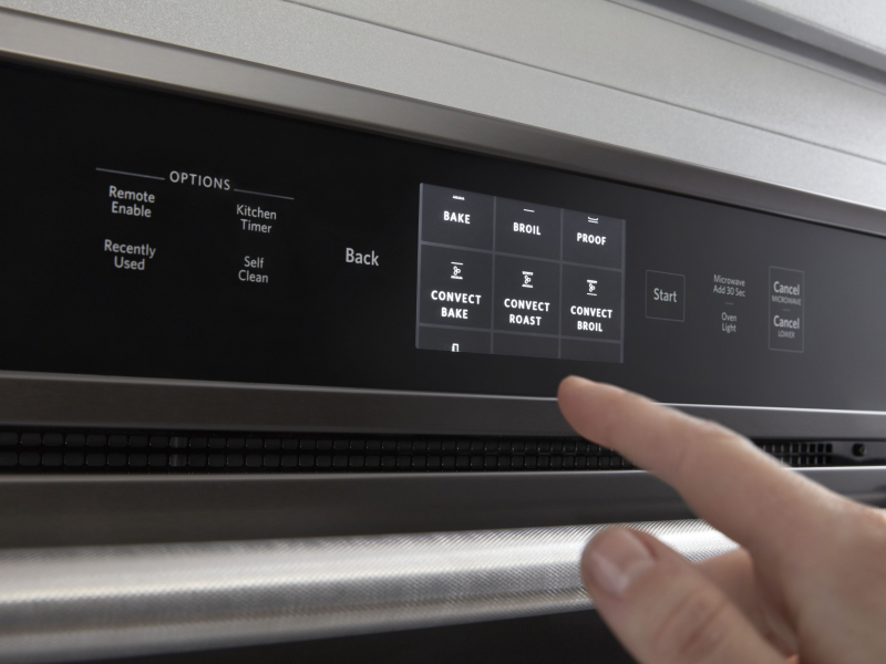 Person selecting a bake setting on a KitchenAid® wall oven