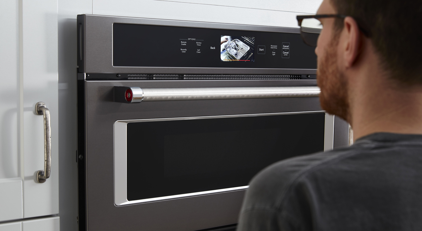 Person standing in front of a KitchenAid® wall oven