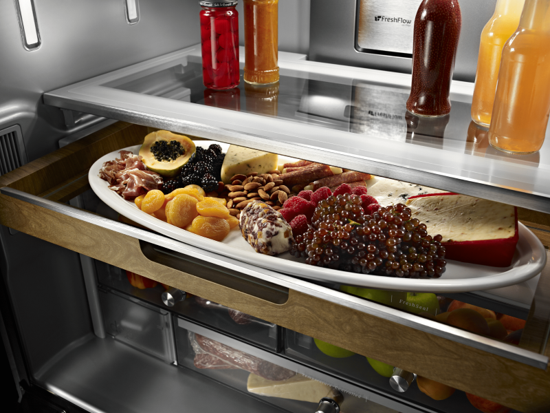 A sliding storage tray with fruits and cheeses.