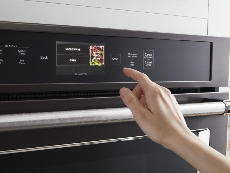 Person selecting a cook setting on a KitchenAid® oven control panel