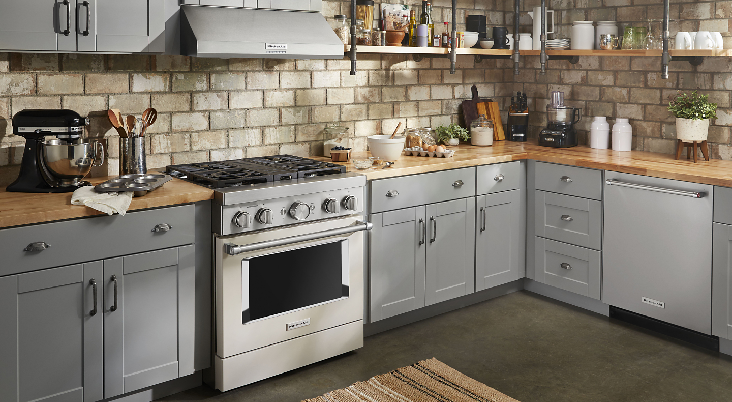 Stainless steel KitchenAid® gas range in a rustic kitchen