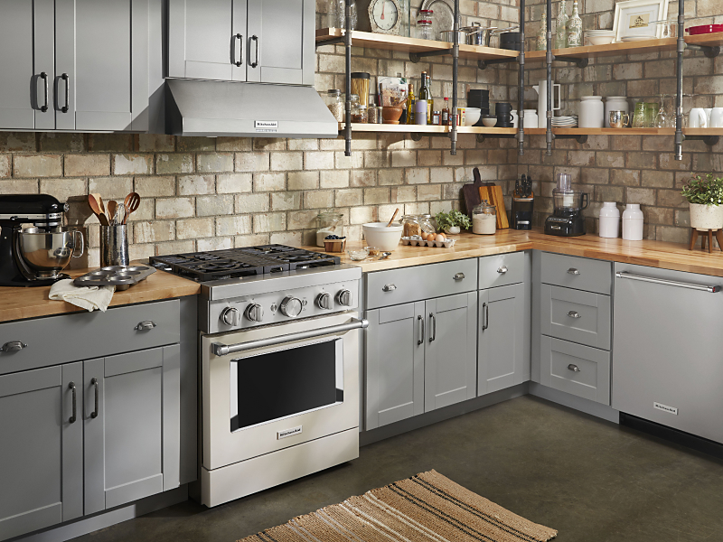 Stainless steel KitchenAid® gas range in a rustic kitchen