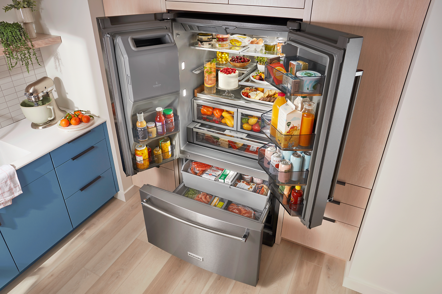 Open KitchenAid® French door refrigerator filled with fresh ingredients