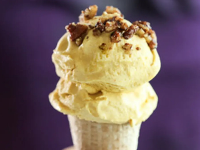 Scoops of pumpkin pie ice cream on a cone