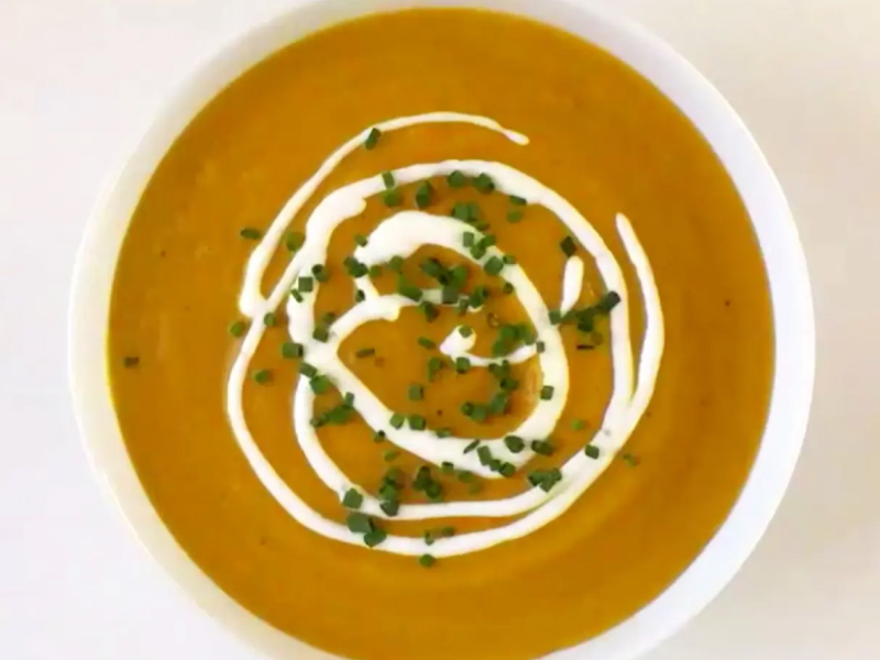 Creamy pumpkin soup garnished with green onions